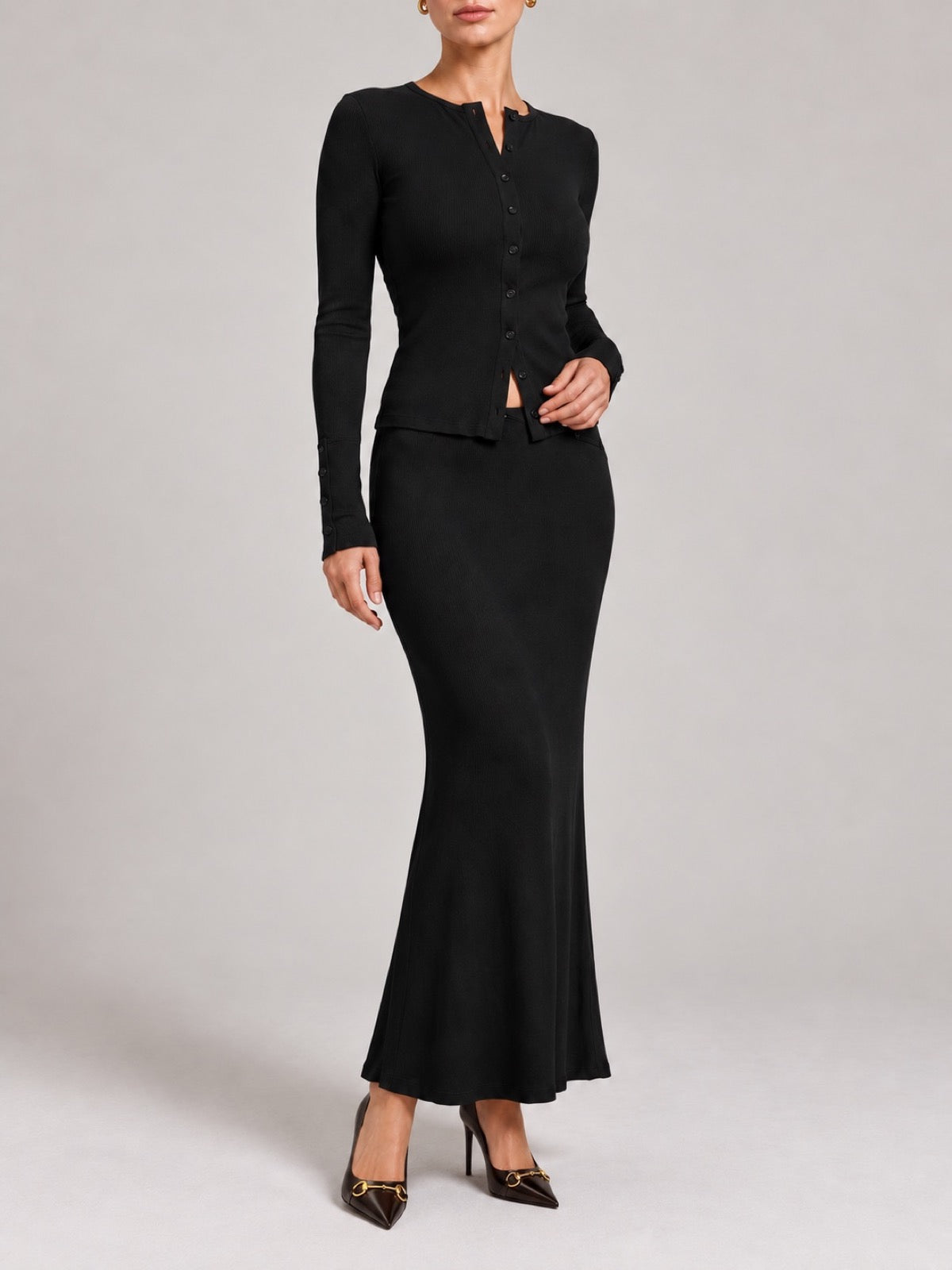 DAPHNE Black cardigan and maxi skirt set with black closed-toe pumps.