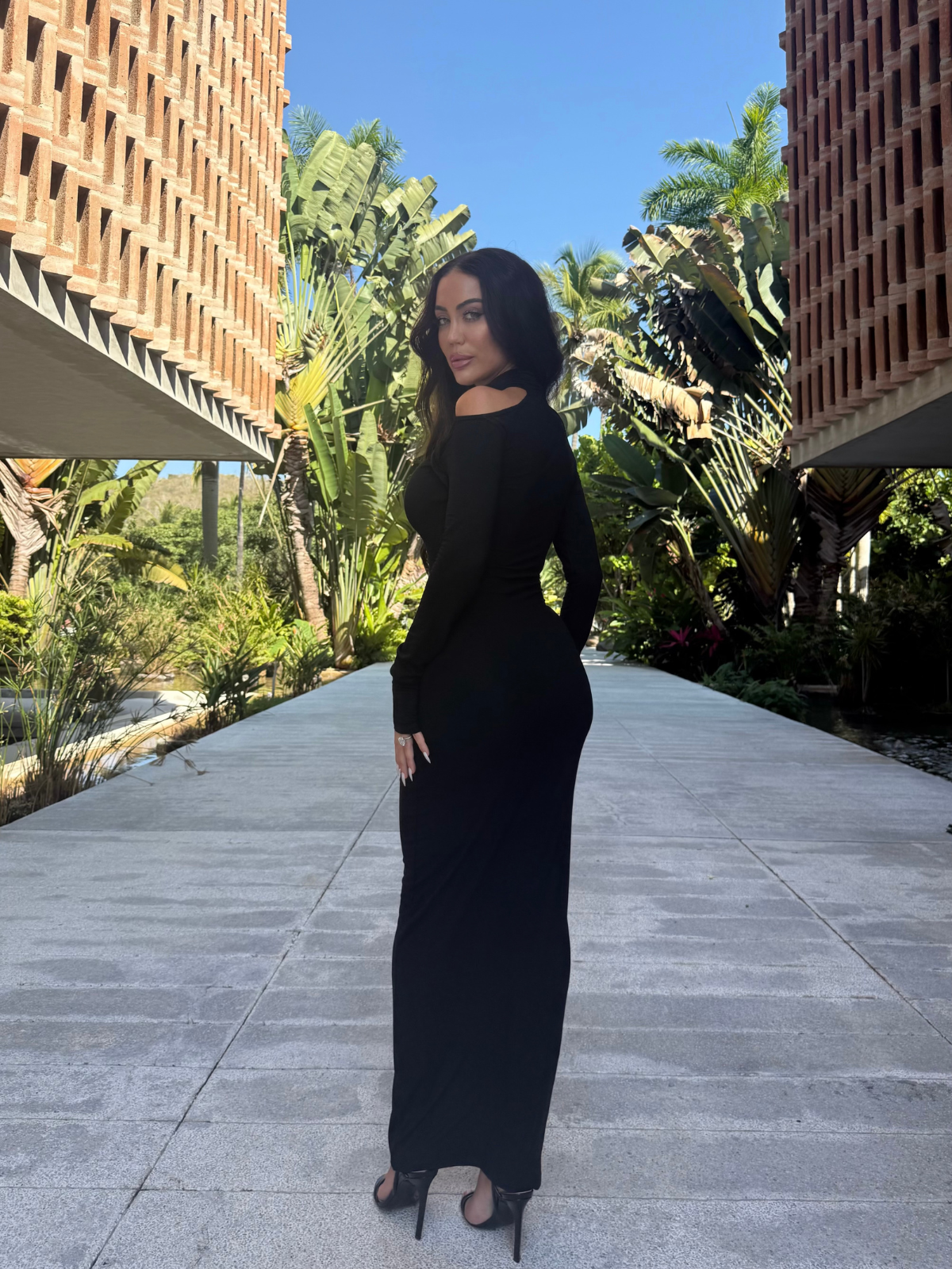 Black bodycon maxi dress with long sleeves outdoor walking pos