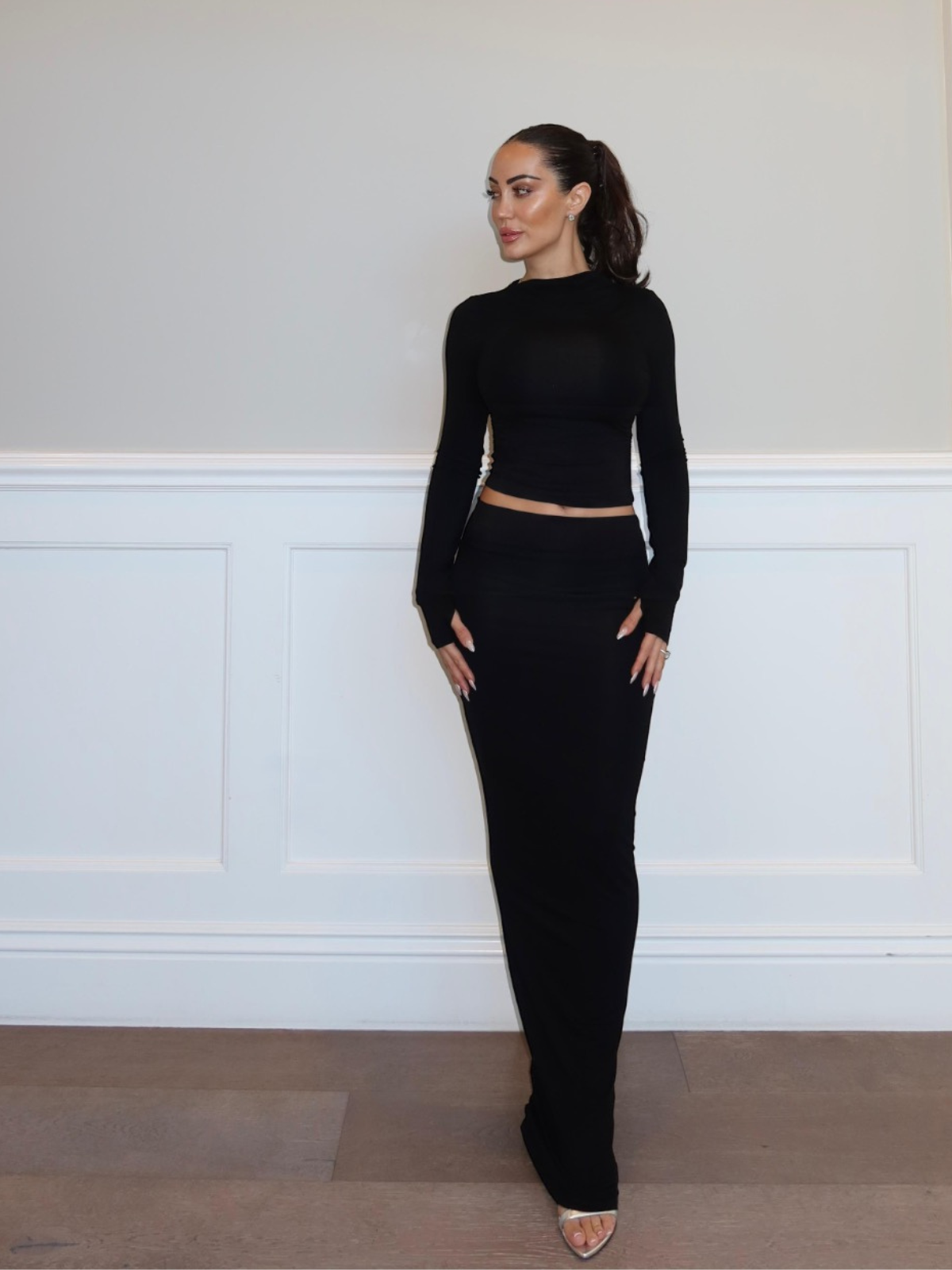 Black two piece matching set with long sleeve crop top and bodycon maxi skirt, front view