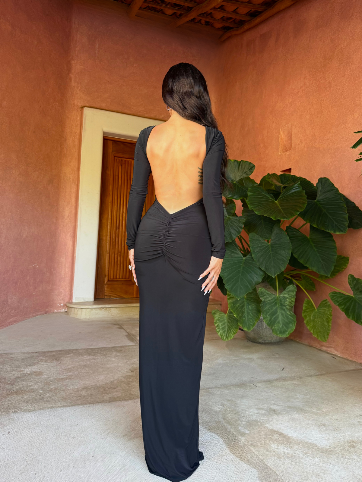 Black open back maxi dress with long sleeves outdoor back view