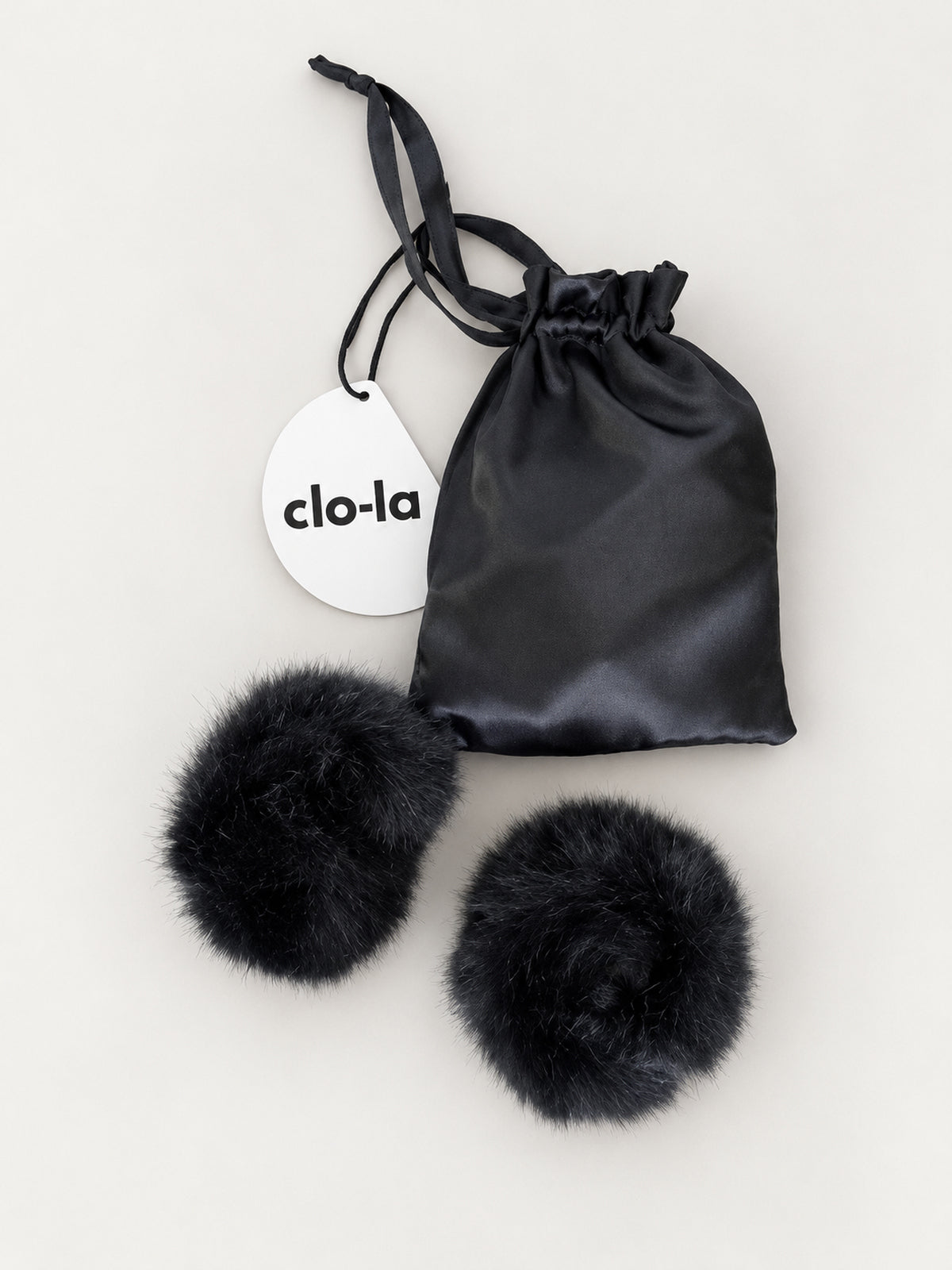 Black faux fur slap cuffs with satin pouch and clo-la tag