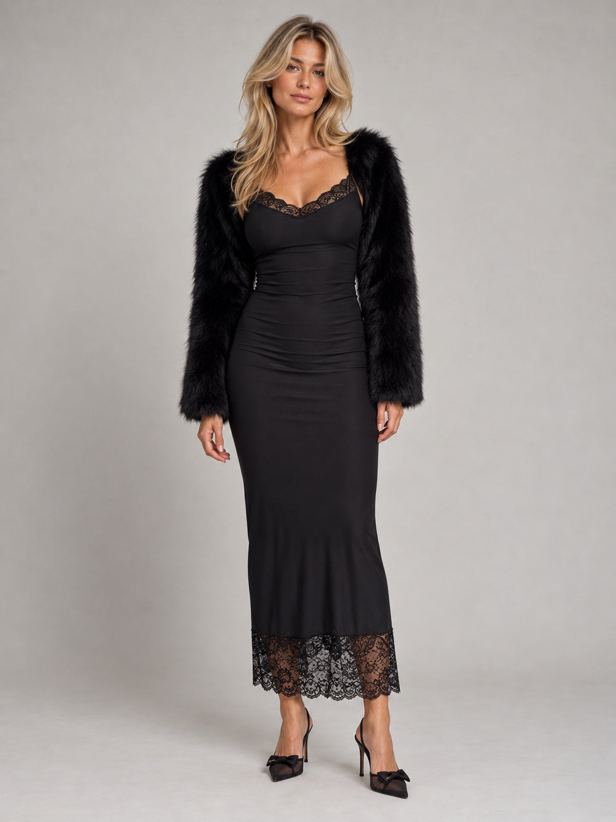 Svart faux fur-bolero över svart spetsklänning, helfigur framifrån