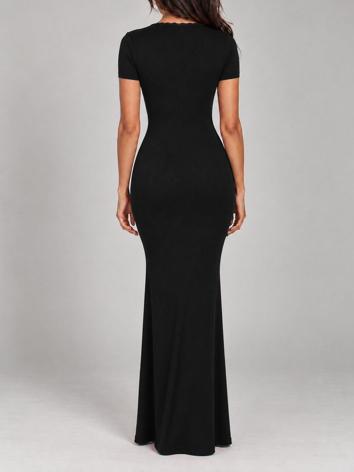 BREE black maxi dress, faceless back view with close-fitting short sleeves, fine ribbing and an even floor-length hem covering the shoes.