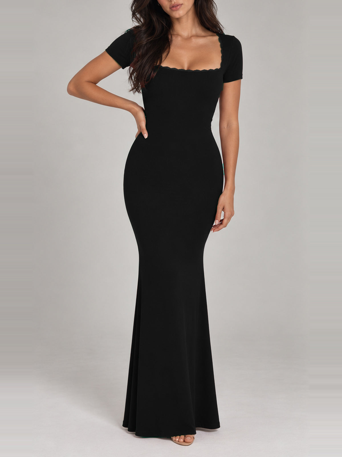 BREE black maxi dress, faceless front view with one hand at the waist, close-fitting short sleeves and fine ribbing.