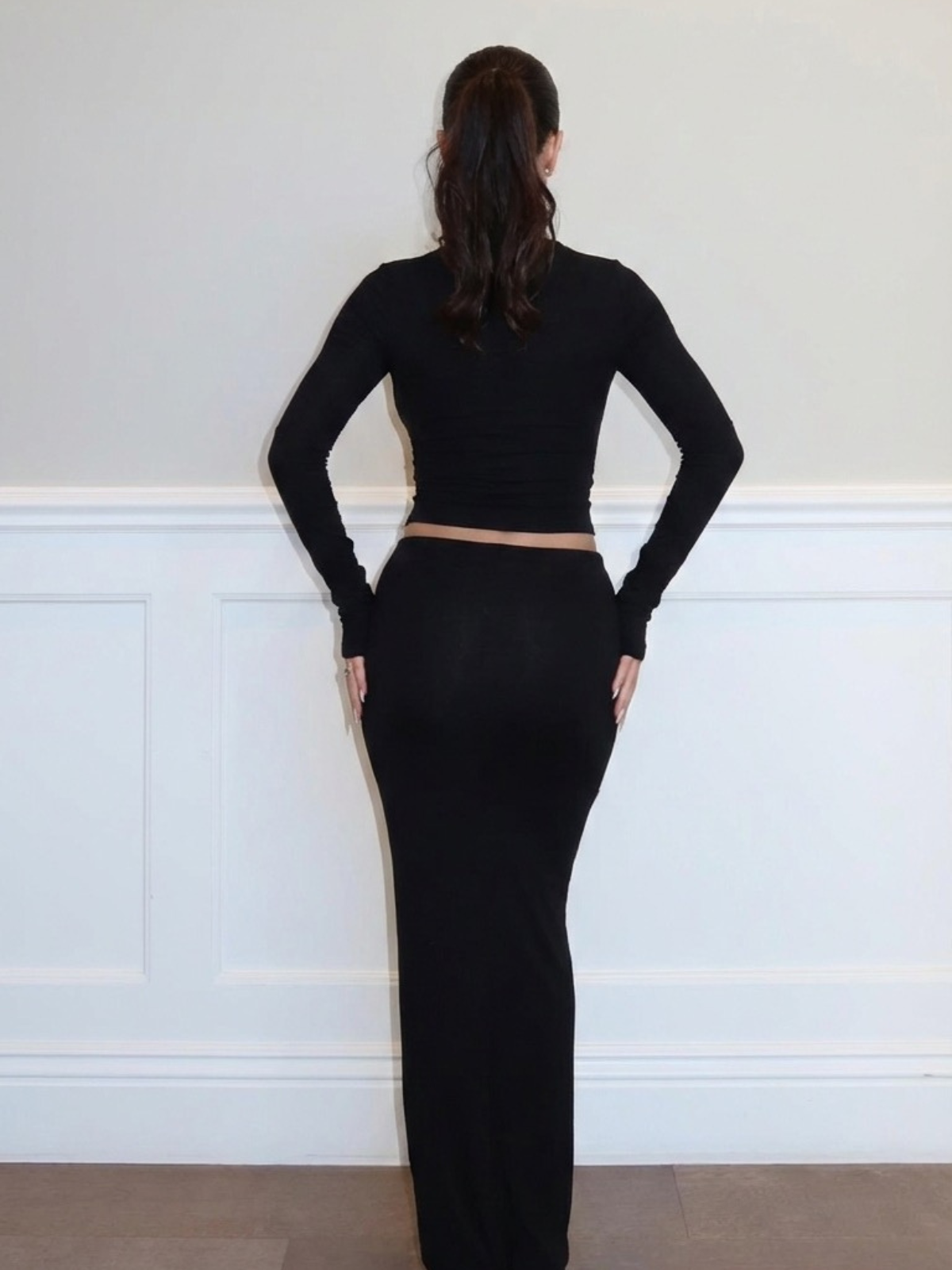 Black two piece set with fitted crop top and maxi skirt, full length back view